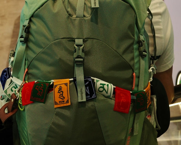 Green backpack with prayer flags attached