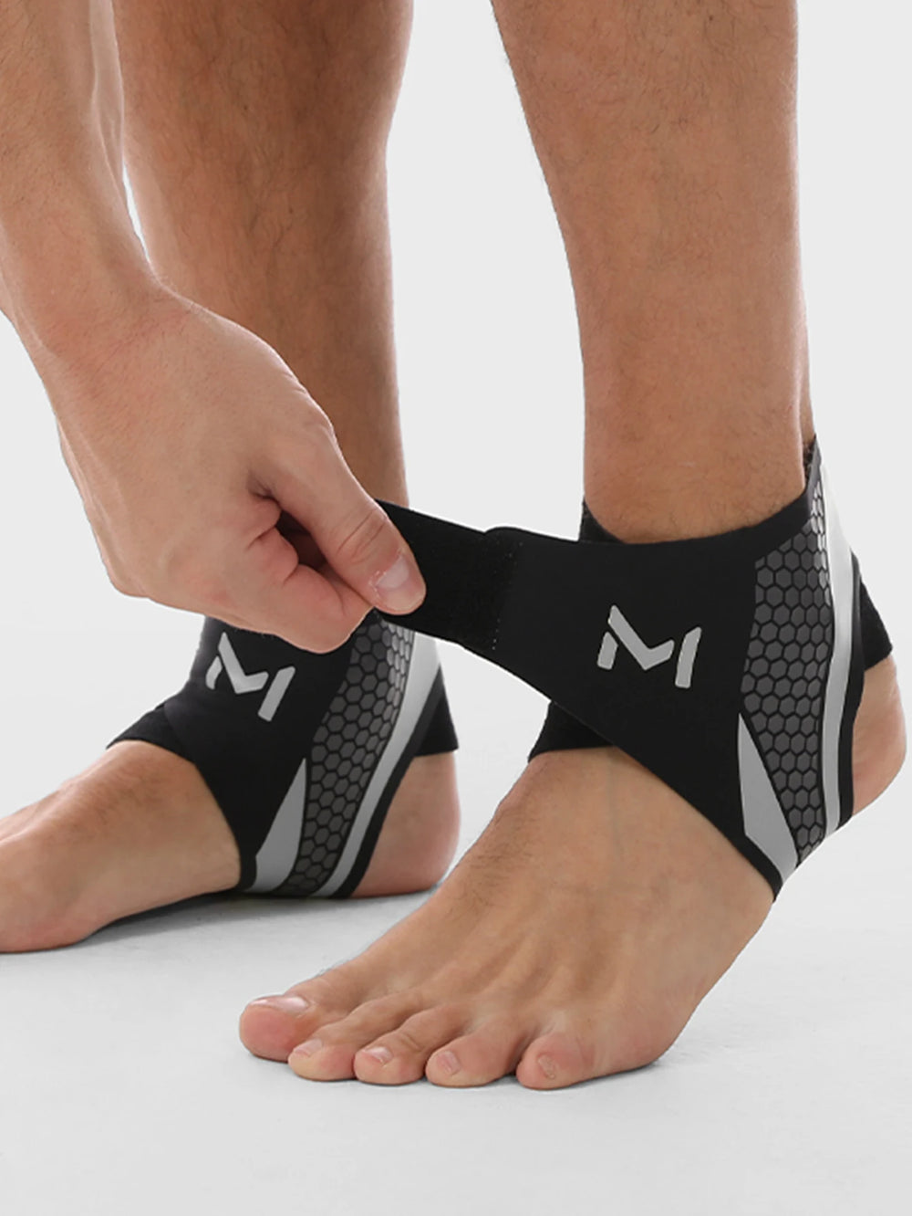 Valour Fit adjustable ankle compression support sleeve shown on a person's ankle, providing stabilization and compression for injury relief.
