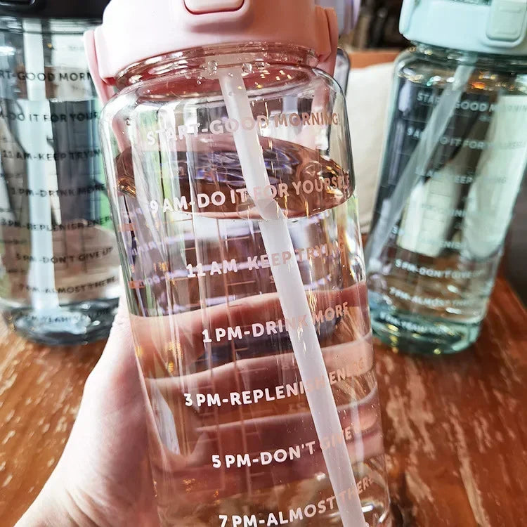 Valour Fit 2L straw water bottle with time marker, clear plastic design, leak-proof lid, and ergonomic grip for hydration.